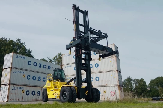 Electric Hyster container handler next to stacked containers
