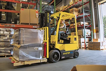 Female forklift operator transporting a pallet